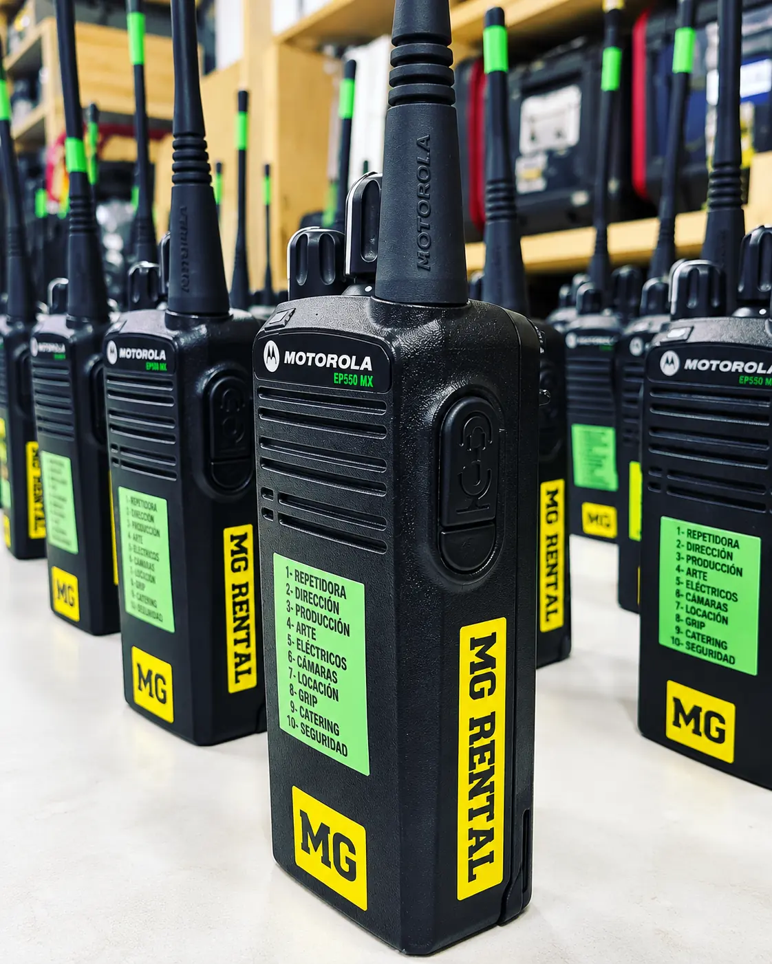 Radios Motorola con etiquetas amarillas MG Rental y lista de canales por área de producción.